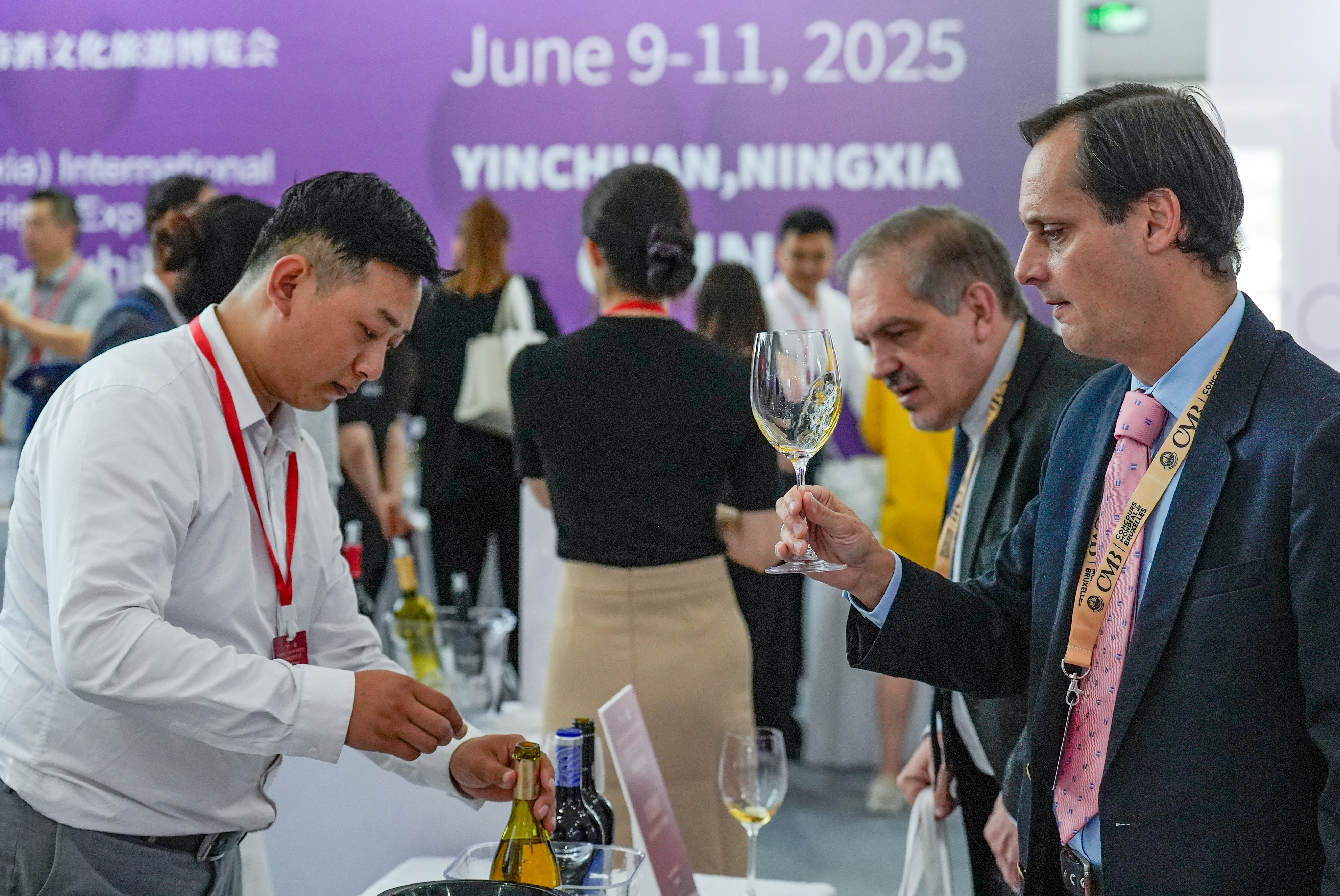 A visitor (1st R) tastes wine at the Global Wineries Exhibition during the Fifth China (Ningxia) International Wine Culture and Tourism Expo in Yinchuan, northwest China's Ningxia Hui Autonomous Region, on June 9, 2025.(Xinhua/Yang Zhisen)
